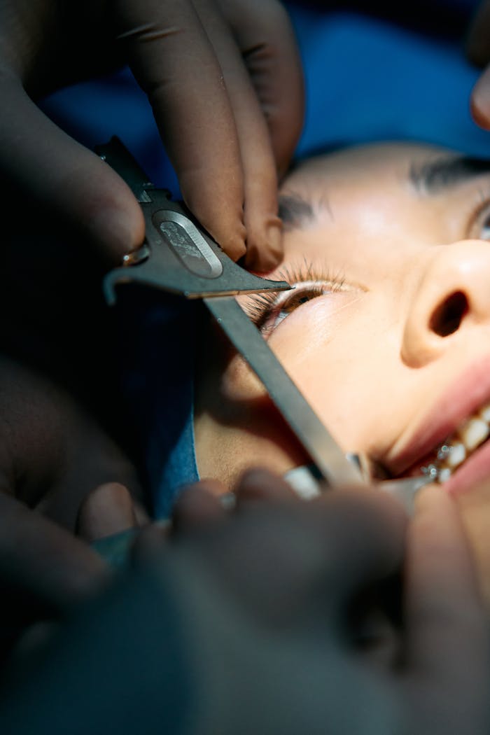 Detailed view of a surgical operation on the eye, showing precision instruments in use.